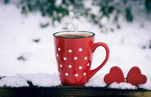 taza roja con lunares con café negro caliente foto