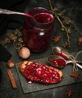 tostadas con mermelada de frambuesa y tarro de mermelada vacío foto