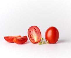 ripe red whole tomatoes and pieces on a white background