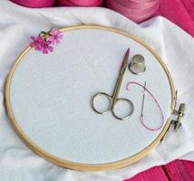 wooden round hoop with white fabric for embroidery and scissors photo