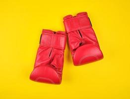 pair of red leather boxing gloves on a yellow  background photo