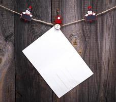 poste de papel blanco vacío colgando de una cuerda foto