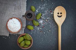 aceitunas verdes y sal en tazones de madera foto