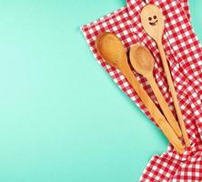 wooden spoon with a carved face on a red kitchen towel photo