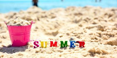 multicolored wooden letters in the word summer on sand photo