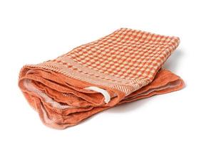folded orange linen towel on white background photo