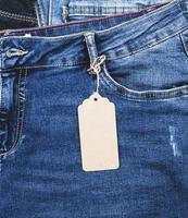 jeans azules con una etiqueta vacía de papel marrón en una cuerda foto