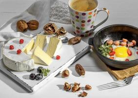 fried eggs in a white black cast-iron frying pan and coffe photo