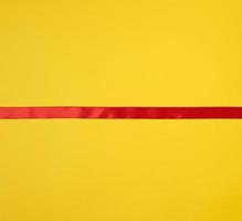 red silk ribbon on a yellow background, festive backdrop photo