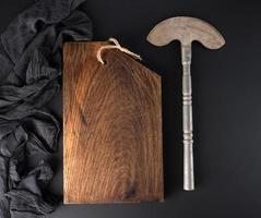 empty brown cutting board and old iron hatchet for cutting meat or vegetables photo