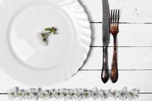 White empty plate with cutlery on a wooden surface photo
