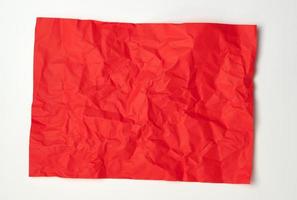 crumpled red rectangular sheet of paper on a white background photo