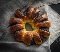 baked round pie with poppy seeds on a gray linen napkin photo