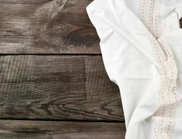 white kitchen textile towel folded on a gray wooden table from old boards, top view, empty space photo