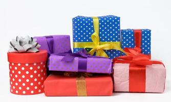 stack of boxes wrapped in paper and tied with a silk ribbon on a white background, celebration. photo