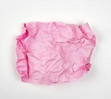 crumpled pink rectangular sheet of paper on a white background photo