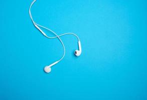 white earphones with a cable on a blue background photo