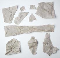 set of various pieces of torn gray crumpled paper on a white background photo