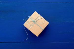 brown cardboard gift square box on a blue wooden background photo