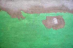 fragment of green cement wall with irregularities