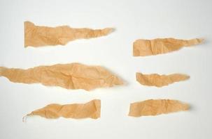 torn brown pieces of parchment paper on a white background photo