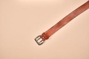 fragment of a brown leather belt with an iron buckle photo