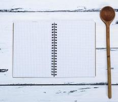 abra el cuaderno vacío en una caja y una cuchara de cocina foto