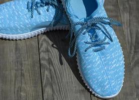 pair of textile blue shoes on a gray wooden surface photo