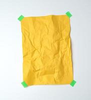 empty yellow crumpled sheet of paper glued with green sticky pieces of paper photo