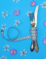 iron fork and knife wrapped in a measuring tape photo