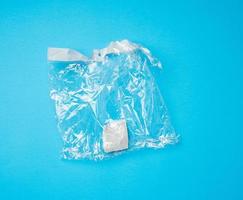 blank transparent plastic bag on blue background photo