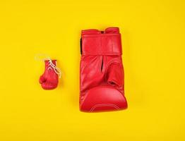 two red boxing gloves on a yellow background photo