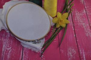 herramientas para costura e hilo de coser con dos colores en el mismo tono con flor de narciso foto