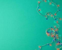 burning christmas garland on a white wire with colorful lights photo