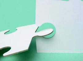 white paper puzzles on a green background, connection photo