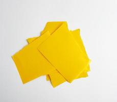 stack of yellow paper torn pieces of paper on a white background photo