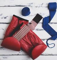 par de guantes de boxeo rojos de cuero, vendaje azul foto