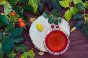 Fruit tea with a viburnumin a transparent checkers among fallen leaves photo