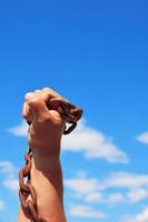 male hand holds a rusty metal chain photo