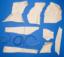 set of various pieces of torn brown crumpled paper on a blue background photo