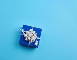 cardboard gift square box, bows, ribbons on a blue background photo