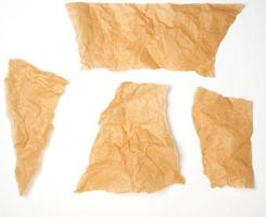 torn brown pieces of parchment paper on a white background photo