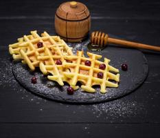 baked wafers with honey on a black background photo