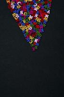 Colored wooden letters on a black surface, empty space from below photo