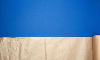 untwisted roll of brown parchment paper on a blue background photo