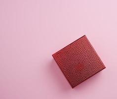 beautiful red shiny closed box on a pink background, concept of congratulations photo