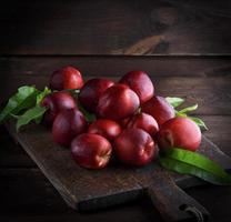 red ripe peaches nectarine on a brown wooden board photo
