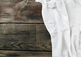 toalla textil de cocina gris blanca doblada sobre una mesa de madera gris de tablas viejas foto