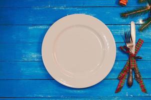 plato blanco, cuchillo y tenedor en una porción festiva para las vacaciones de navidad foto