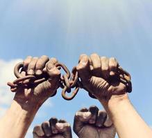 dirty male hands wrapped in a rusty iron chain photo